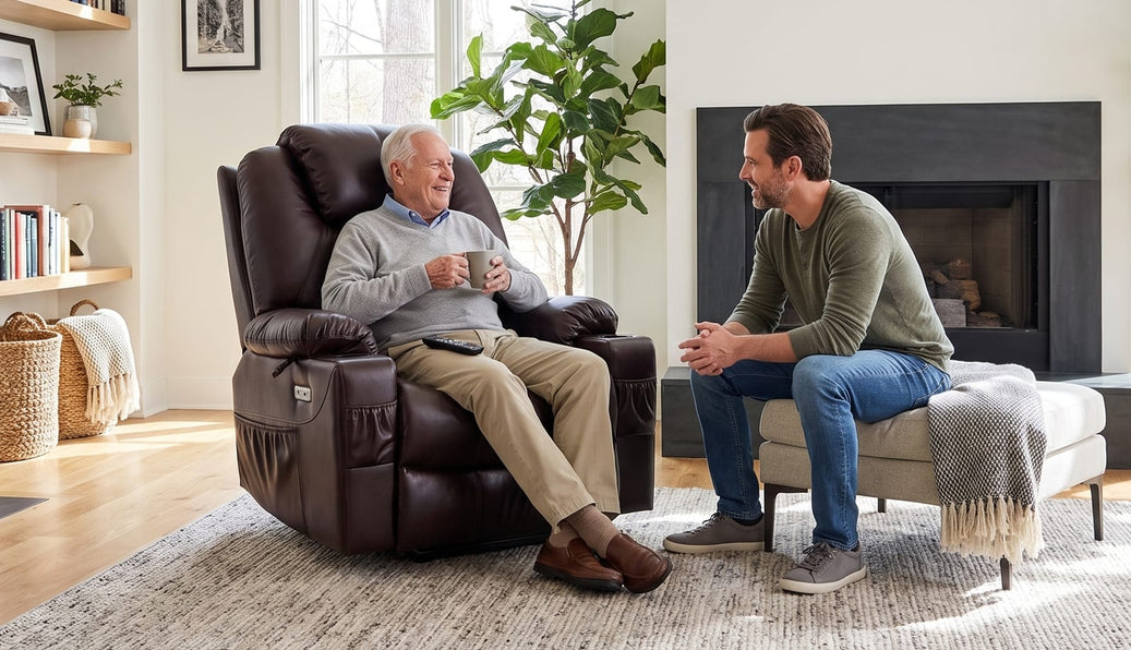 Older man sitting in a brown lift chair with a mug while talking with a younger man on an ottoman
