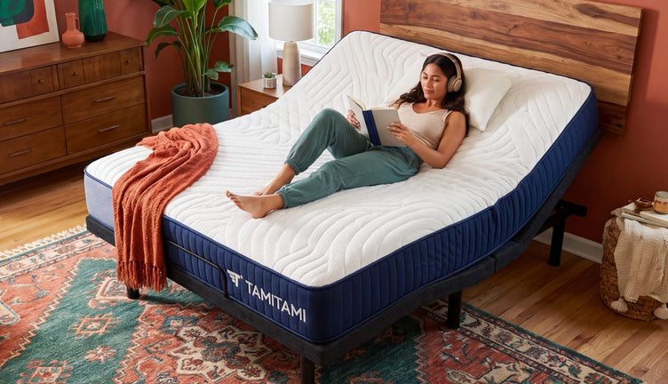Woman reading on a TAMITAMI adjustable bed with the head section raised in a modern bedroom